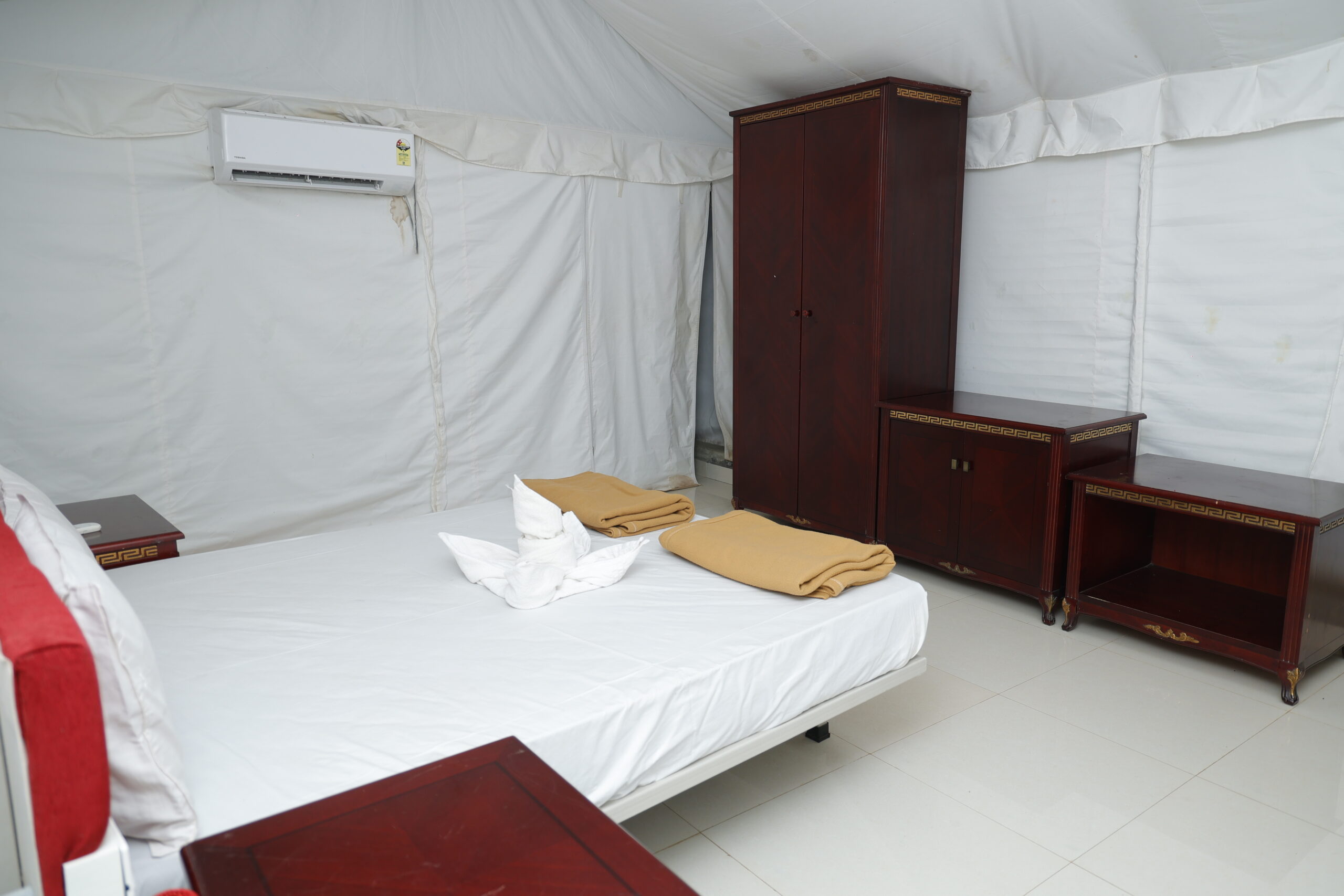 Maharaja tents surrounded by natural greenery at riverside resort in Dandeli