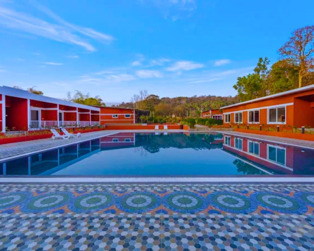 Outdoor swimming pool surrounded by nature at Dandeli resort