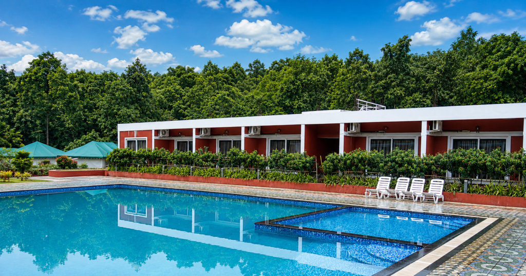 Outdoor swimming pool surrounded by nature at Dandeli resort